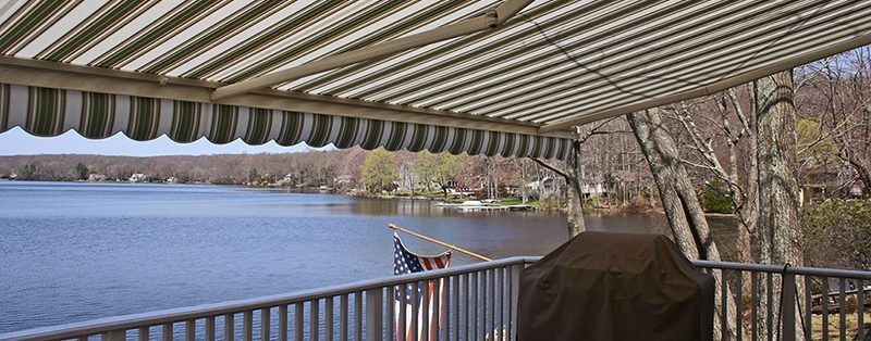 striped patio awning above lake