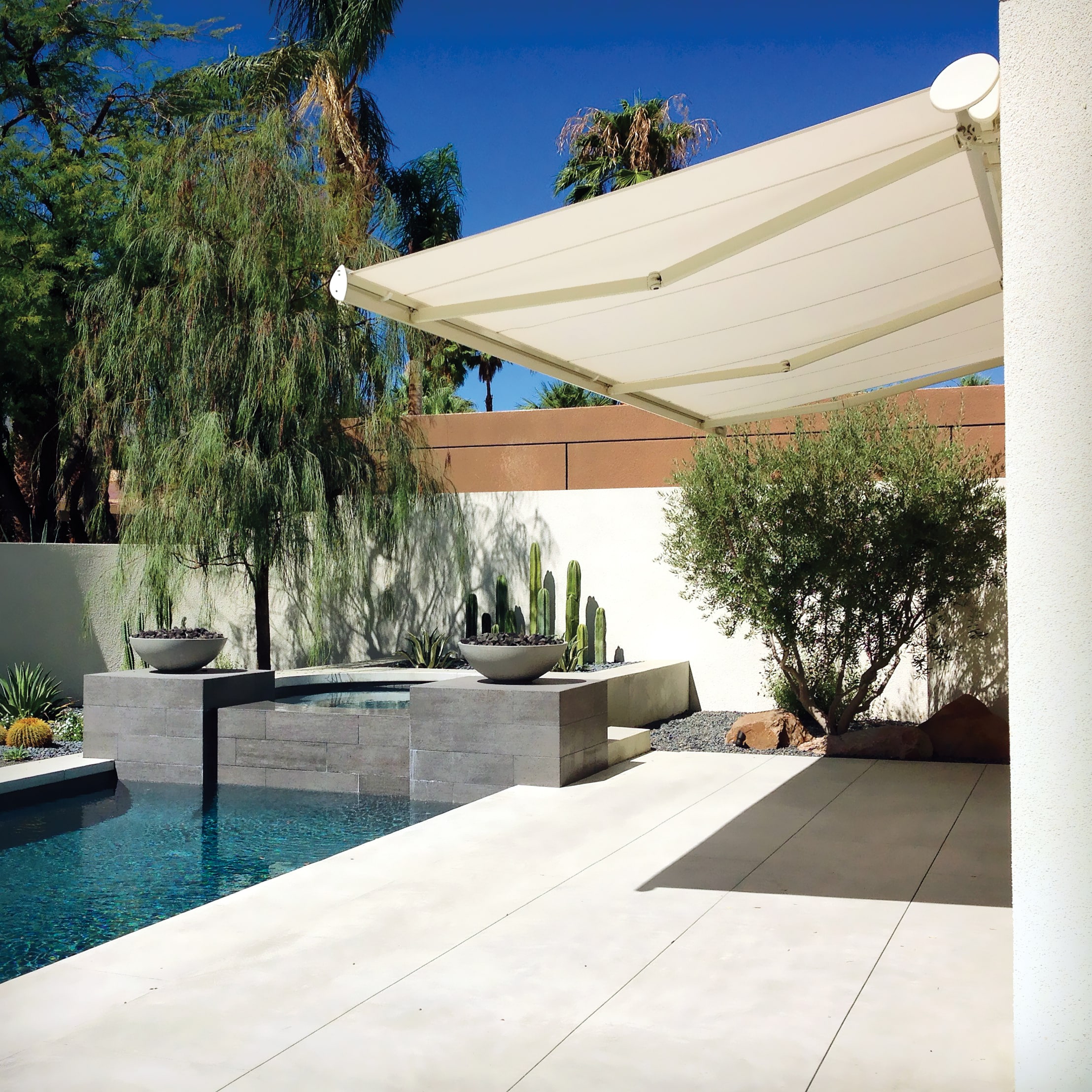 Motorized patio awning by a pool