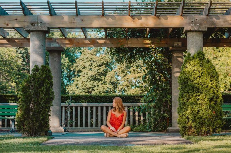 Woman sitting on a patio underneath a pergola