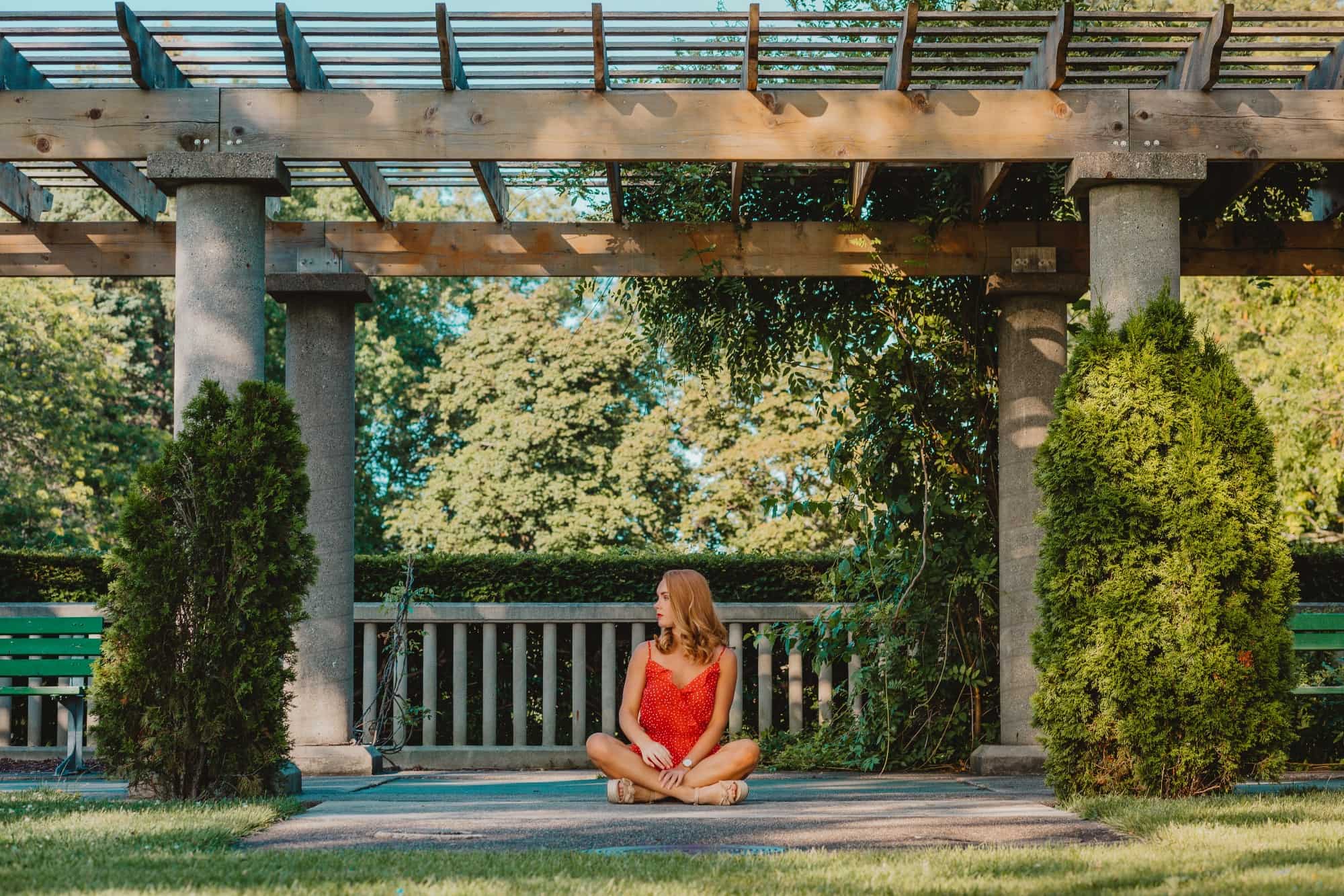 Woman sitting on a patio underneath a pergola